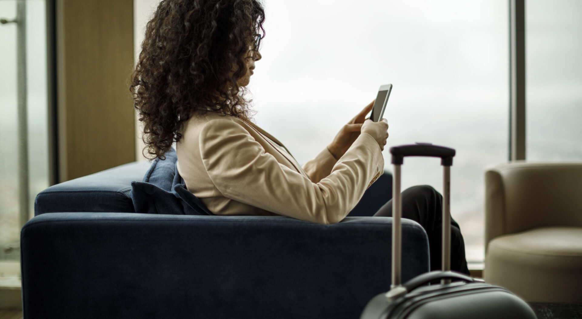Businesswoman using mobile phone in airport waiting area